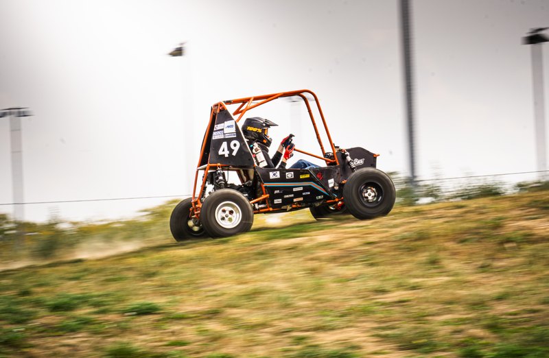 Orange ONU Baja SAE car number 49 testing on a dirt and gravel course