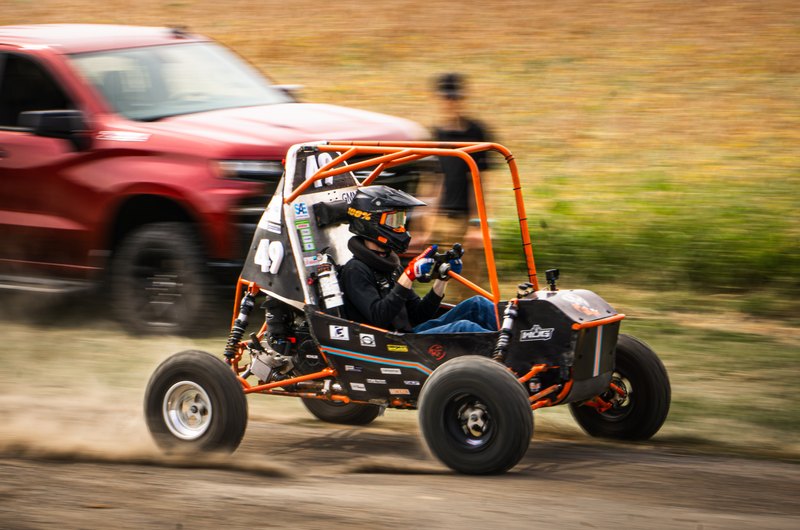 Orange ONU Baja SAE car number 49 testing on a dirt and gravel course