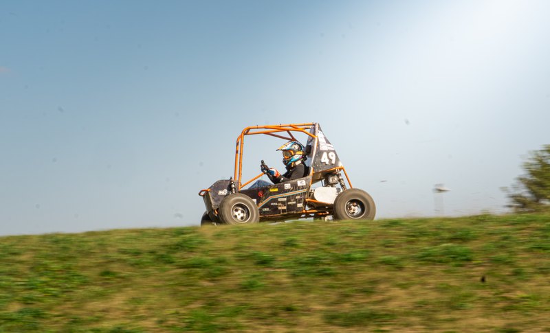 Orange ONU Baja SAE car number 49 testing on a dirt course