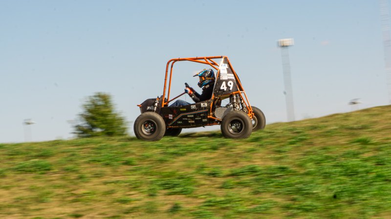Orange ONU Baja SAE car number 49 testing on a dirt course