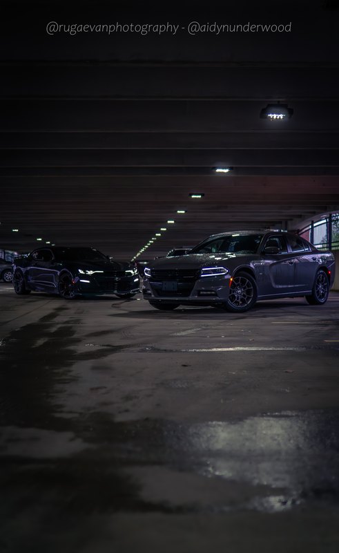 Dark muscle car in a concrete parking garage at night