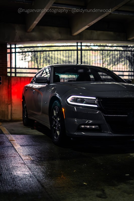 Dark muscle car parked on a concrete garage level