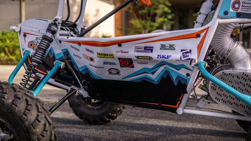 ONU Baja SAE car number 32, white bodywork and teal frame, at its reveal shoot