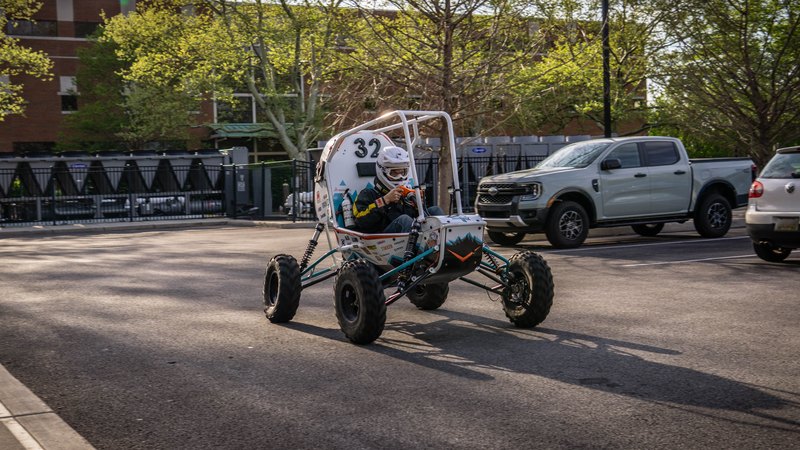 ONU Baja SAE car number 32, white bodywork and teal frame, at its reveal shoot