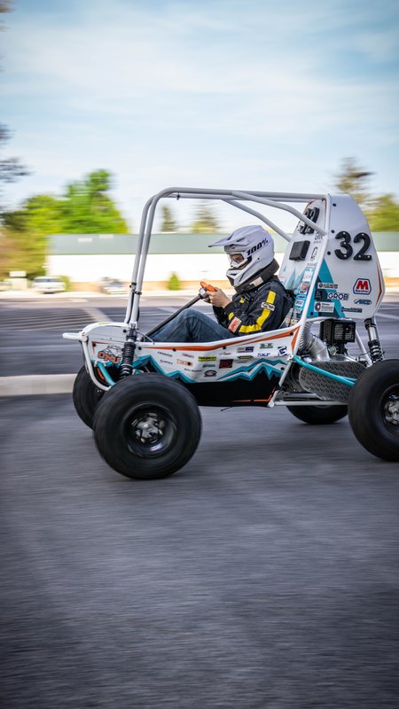 ONU Baja SAE car number 32, white bodywork and teal frame, at its reveal shoot