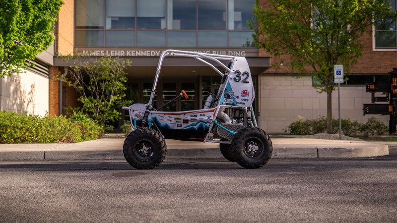 ONU Baja SAE car number 32, white bodywork and teal frame, at its reveal shoot