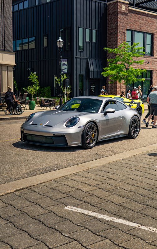Silver Porsche 911 GT3 at a downtown car show